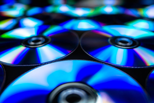 CDs / DVDs deitados sobre um fundo preto com reflexos de luz
. - Foto, Imagem