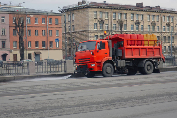 gran máquina de riego naranja lava la parte de la carretera con agua
    - Foto, imagen