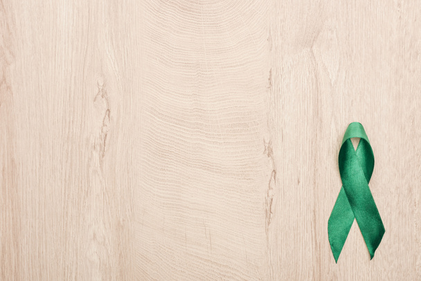 top view of green ribbon on wooden background with copy space  - Photo, Image