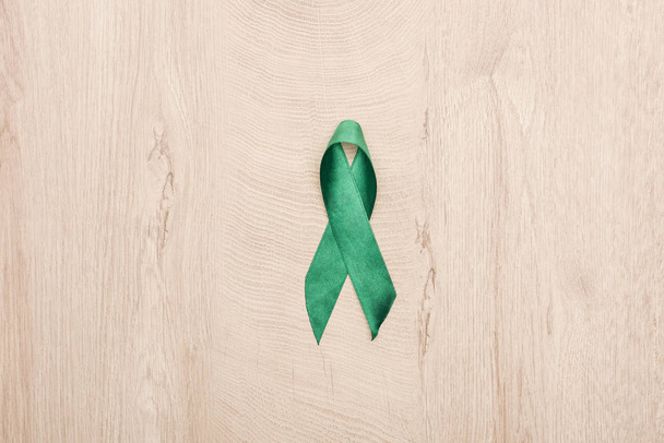top view of green ribbon on wooden background with copy space  - Photo, image