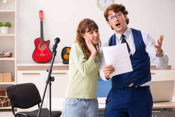 Junge Frau während Musikstunde mit männlichem Lehrer - Foto, Bild