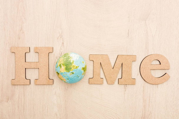 top view of wooden word home and toy planet on wooden background  - Foto, immagini