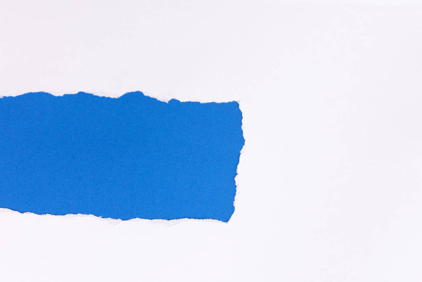 White torn paper over blue background with pencil - Fotó, kép