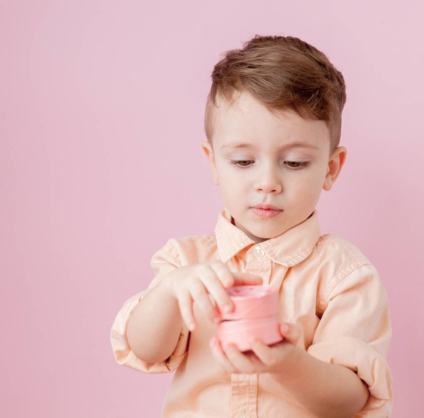 Happy little boy with a gift . Photo isolated on pink background - 写真・画像