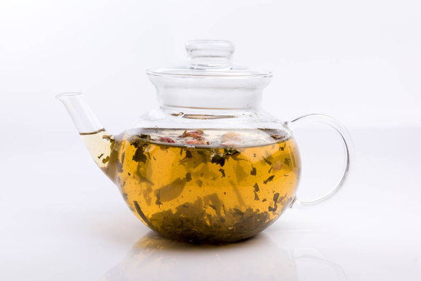 Glass teapot with herbal tea and roses isolated on white background - Foto, Imagem