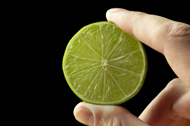 Half lime in the hand of a man. - Photo, Image