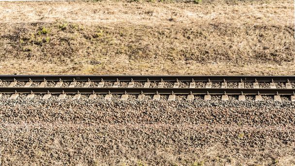 A single-track railway. Spring landscape with dry grass - Photo, Image