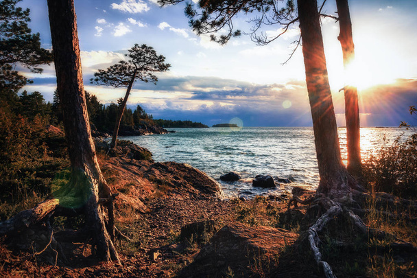 Świecącego słońca jeziora Superior. Podłoże skaliste wybrzeże. - Zdjęcie, obraz