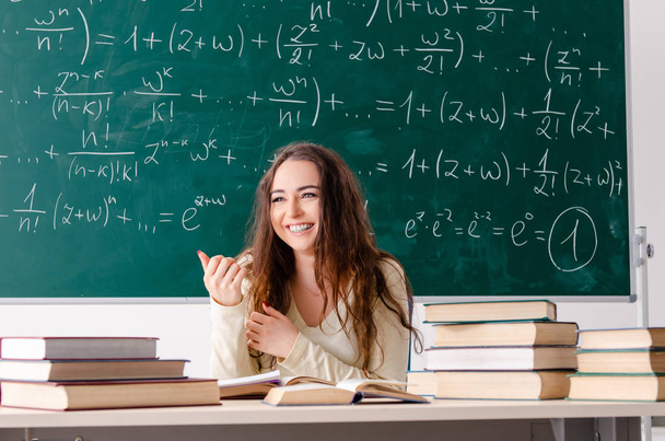 Karatahtanın önünde genç bayan matematik öğretmeni. - Fotoğraf, Görsel