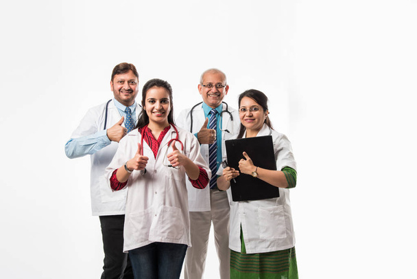 Indian doctors group photo showing success or thumbs up sign. Standing isolated over white background. Selective focus - Photo, Image