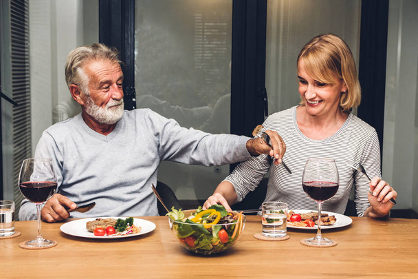 Happy smiling elder senior couple eating dinner and drinking win - Фото, зображення