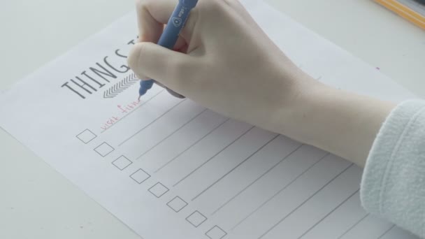 Młoda dziewczyna wypełniająca listę rzeczy do zrobienia w notatniku. - Materiał filmowy, wideo