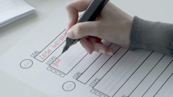 Жінка пише кроки з червоним маркером у списку голів
. - Кадри, відео