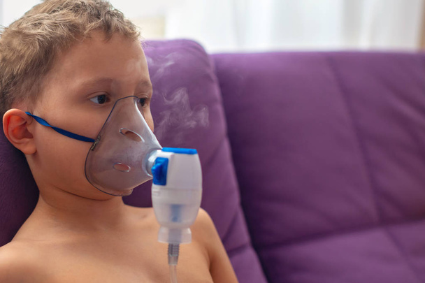 child makes inhalation nebulizer at home. on the face wearing a  - Foto, imagen