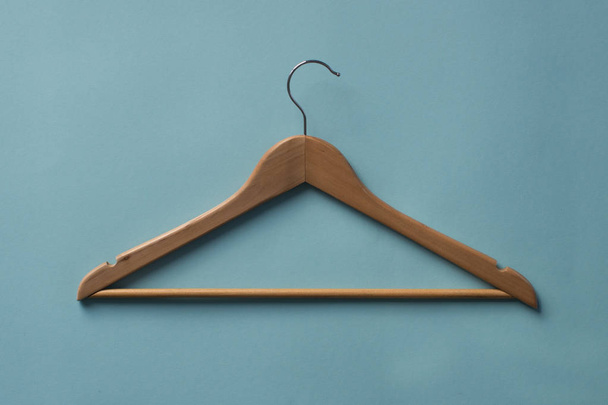 Wooden Clothes hanger on blue background. - Foto, afbeelding