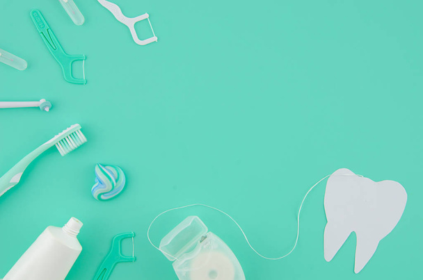 Conjunto de herramientas de equipos médicos para el cuidado dental en el hogar sobre fondo azul. Hilo dental, pasta dental Conceptos básicos de higiene oral
 - Foto, imagen
