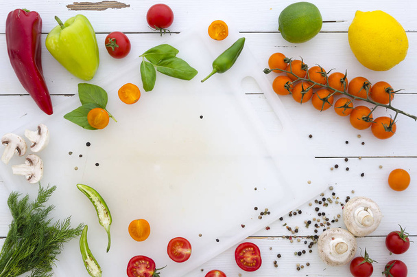 tasainen lay Kehys vihanneksia ja mausteita valkoisella puupohjalla
 - Valokuva, kuva