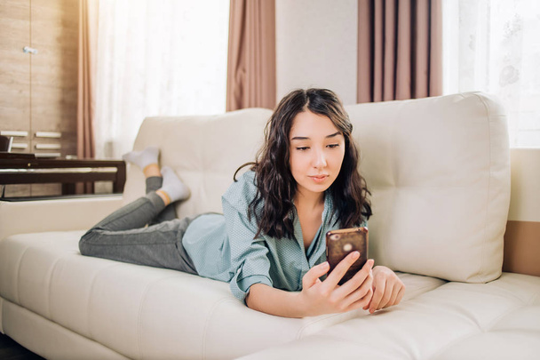 Young woman using smartphone at home - Fotoğraf, Görsel