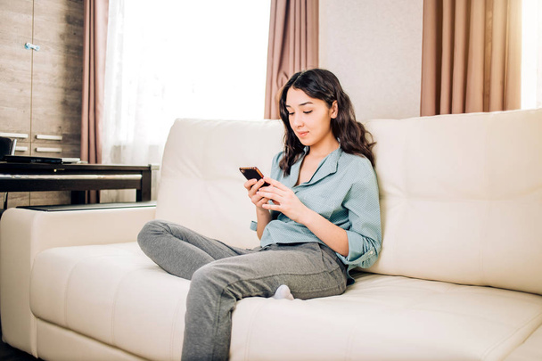Young woman using smartphone at home - Foto, afbeelding
