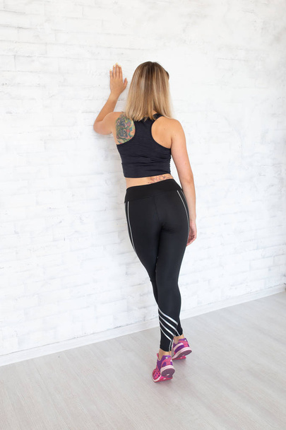 Rear view of sitting sportive woman wearing sexy leggings and to - Photo, Image