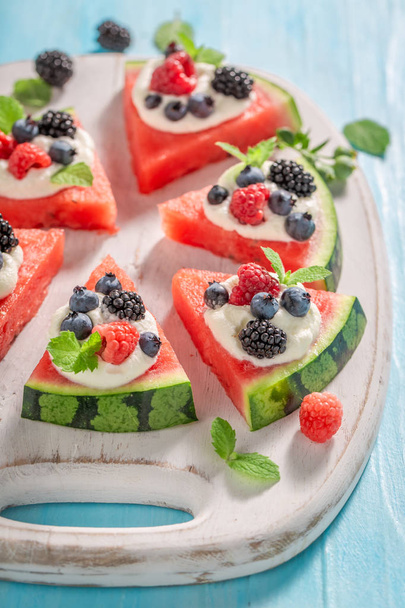 Delicious watermelon pizza with berries, whipped cream and mint leaves - Foto, Bild