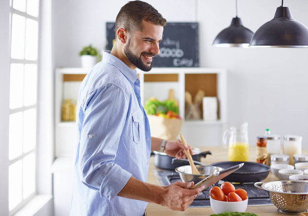 Chef sorridente e confiante em pé na grande cozinha - Foto, Imagem