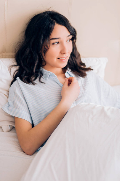 Beautiful woman sitting in bed in morning - Фото, зображення
