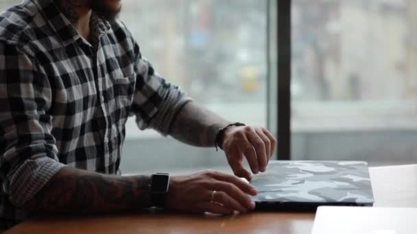 Κομψός όμορφος άντρας ελεύθερος επαγγελματίας που εργάζεται με φορητό υπολογιστή που κάθεται στο καφέ - Πλάνα, βίντεο