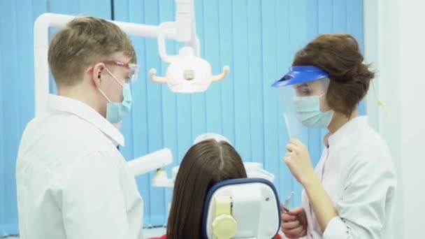Erkek ve kadın diş hekimleri maske ve gözlük. Medya. İşe gitmek hazır ekipman ile koruyucu steril üniformalı ortakları diş hekimleri - Video, Çekim