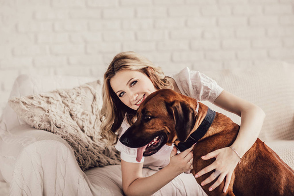young pregnant young woman hugging her dog - Фото, изображение