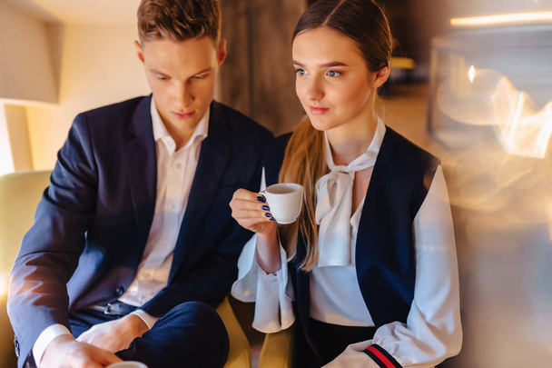 Стильная пара пьет утренний кофе в кафе, молодые бизнесмены и фрилансеры
 - Фото, изображение