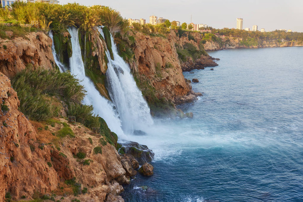 De pittoreske lagere Duden waterval is één van de mooiste natuurlijke bezienswaardigheden van het land, haar sterke waterstroom creëert de kleurrijke regenboog boven de zee, Antalya, Turkije. - Foto, afbeelding