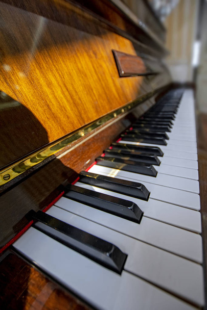 Wide angle vertical view of piano keys lit by sunlight. Piano keyboard with selective focus. Diagonal view. Piano keyboard perspective. Music instruments series - Photo, Image