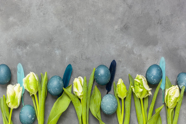 Pâques - Tulipes et œufs œufs bleus tachés de chou rouge sur fond de béton
 - Photo, image
