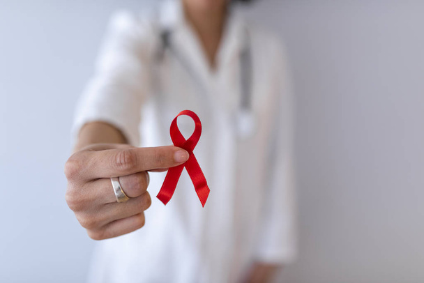 Female doctor holding red cancer awareness ribbon - Zdjęcie, obraz