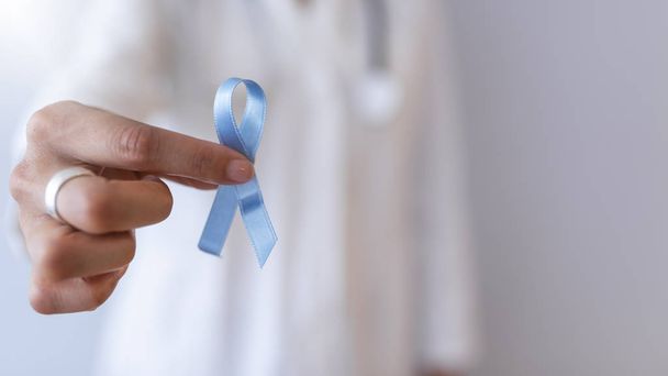 Female doctor holding blue cancer awareness ribbon - Фото, изображение