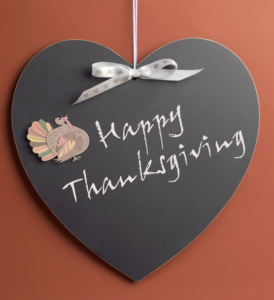 Happy Thanksgiving message written on heart shape blackboard with turkey motif decoration. - Photo, Image