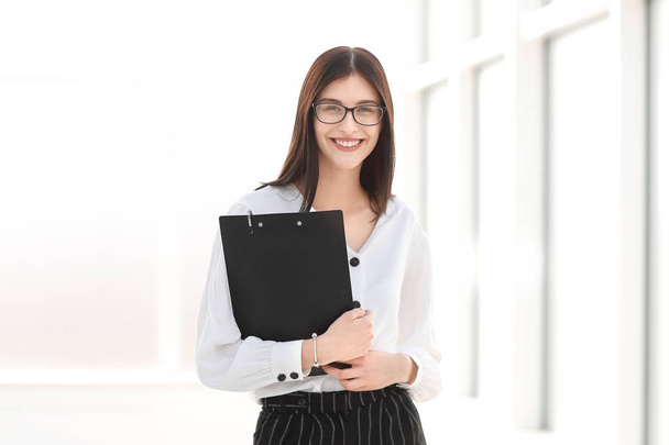 smiling businesswoman with documents standing in the office. - Foto, imagen