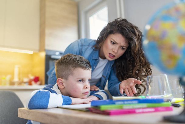 Mother scolding little boy for poor schooling and homework at home - Foto, Bild
