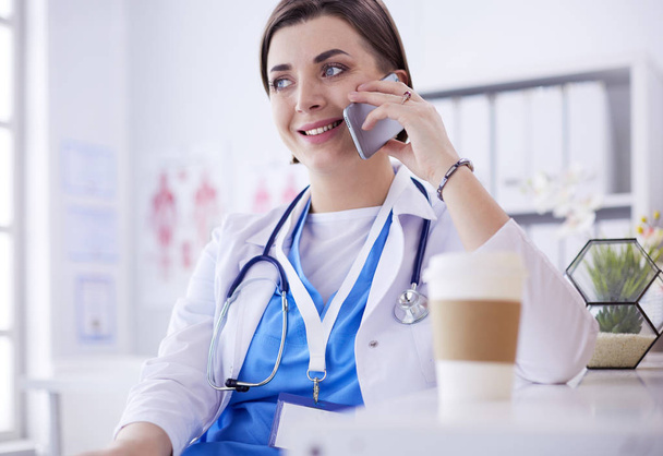 Female doctor talking on phone in diagnostic center - Valokuva, kuva
