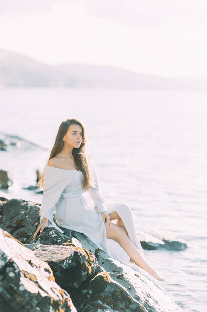 Girl in boudoir dress on the lake, standing and smiling. Unity with nature, morning bride in Russia. Beautiful eyes and model appearance - Φωτογραφία, εικόνα