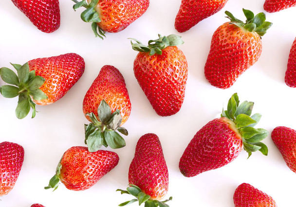 Fond alimentaire avec beaucoup de fraise juteuse sur fond blanc.Fruits mûrs estivaux.Délicieux fruits
. - Photo, image