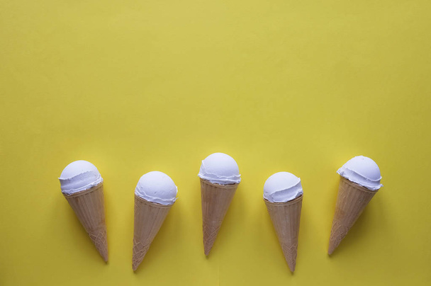 Rangée de cônes de crème glacée vanille sur jaune
 - Photo, image