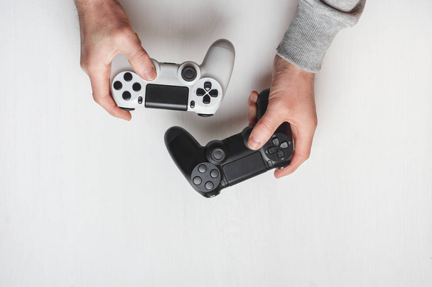 Hand hold new joystick isolated. Gamer play game with gamepad controller. Gaming man holding simulator joypad. Person with keypad joystic in arms. Sleeve hands hold toy equipment. Modern manipulator. - Foto, imagen