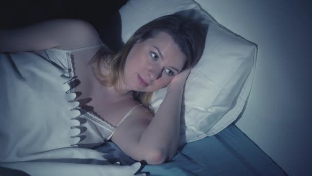 Woman with insomnia lying in bed with open eyes - Záběry, video
