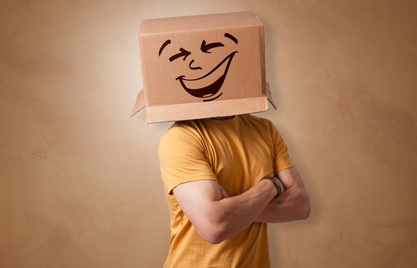 Young boy with happy cardboard box face - 写真・画像