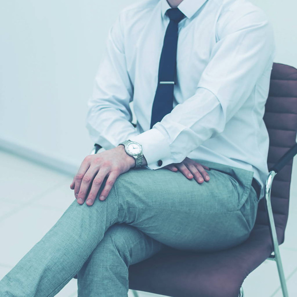 concept of business success - businessman sitting on a chair in  - Фото, изображение