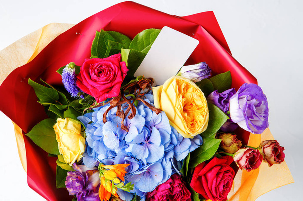 Foto shůry pestrobarevným růží s kartou na prázdné pozadí - Fotografie, Obrázek