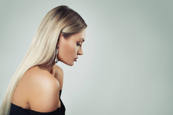 Frau Mode-Modell mit blonden Haaren, Make-up und schwarzen Perlen Ohrringe auf dem Hintergrund mit Kopierraum, Profil - Foto, Bild