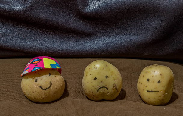 Three fresh potatoes on a brown couch lazy concept - image with copy space in landscape format - Photo, Image